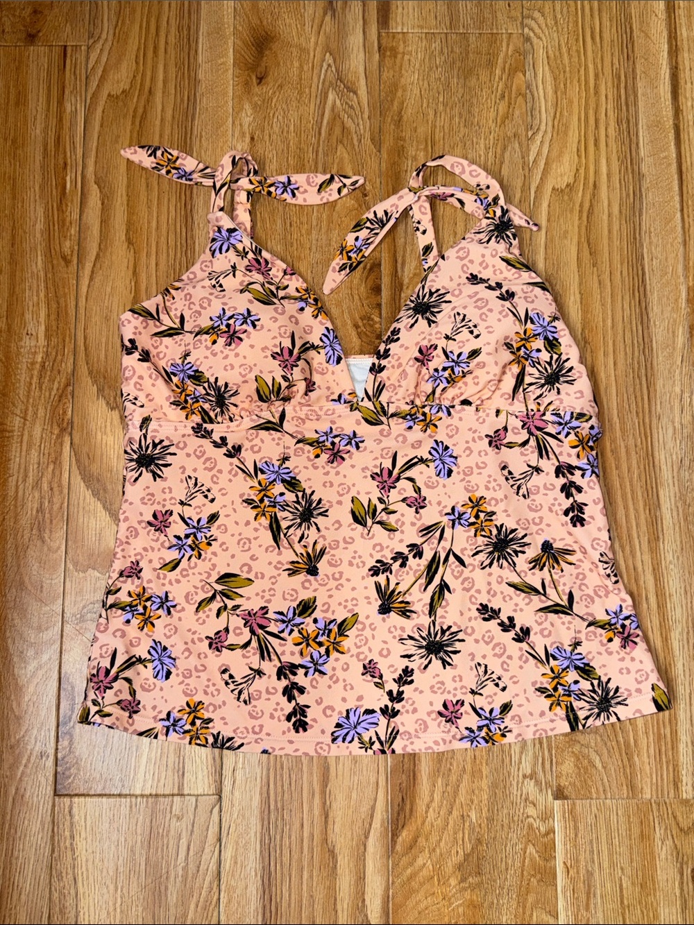 Soft peach floral halter tankini top with adjustable tie straps. Flattering V-ne
